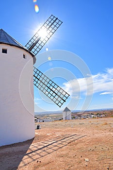 View of half a mill with the sun glaring between its blades.