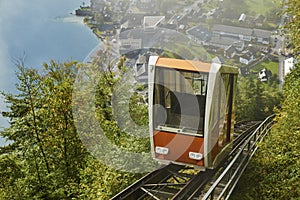 View of a Hallstatt cable car from the top station leading to a skywalk view in Austria with mist in the background.