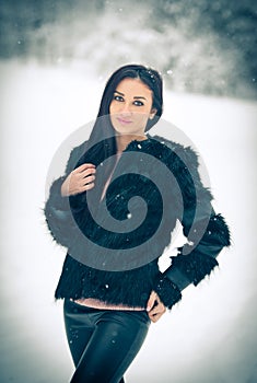 View of happy brunette girl playing with snow in winter landscape. Beautiful young female on winter background. Attractive woman