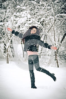 View of happy brunette girl playing with snow in winter landscape. Beautiful young female on winter background. Attractive woman