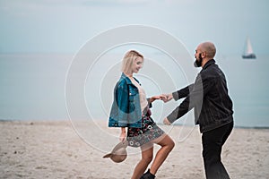 Happy young couple have fun on the beach, holding hands.