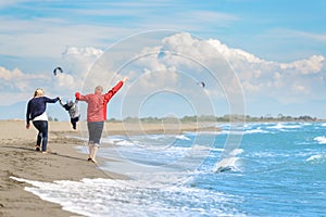 View of happy young family having fun on the beach