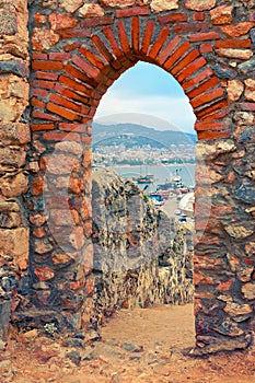 View of harbor through stone arch of Alanya Castle