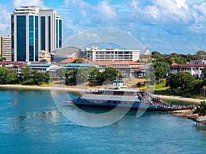 View from harbor to the blue color ferry with black people come out from passenger vessel in Dar Es Salaam. photo