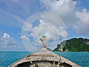View from the head of wooden long tail boat sailing to the island with beautiful blue sky and cloud from Thailand