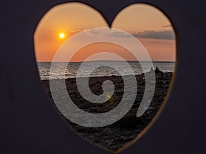 View through heart over people filming at the seaside