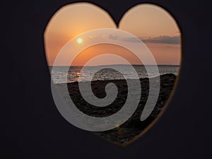 View through heart over people filming at the seaside