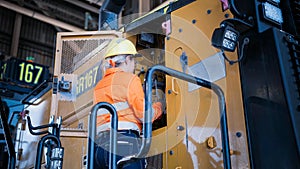 View of a heavy mining machinery operator inspecting the equipment before starting mineral extraction work