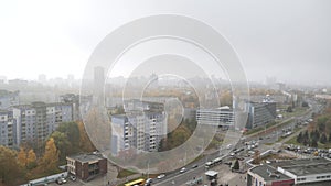 View from height of buildings of big city in autumn, covered with gray fog.