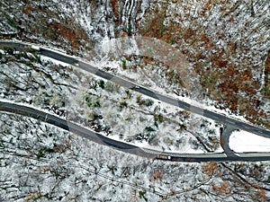 View from height on car driving through winter forest road. aerial eye landscape