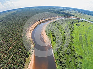 The view from the height of the river Mologa and forest along the sandy shore