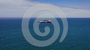 View from the height on a sea vessel for transportation of a dry-cargo ship with a closed hold is anchored near the