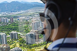 View from a helicopter cockpit flying over Rio de Janeiro. Cockpit with pilot and control board inside the cabin in a sunny day. photo