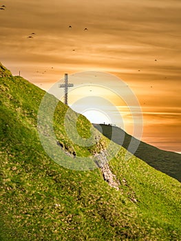 View with the Heroes Cross on Caraiman peak at sunset, in Bucegi Mountains Romania