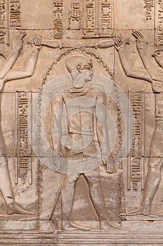 Hieroglyphs on a wall at the Temple of Kom Ombo in the Nile river at sunset, Egypt