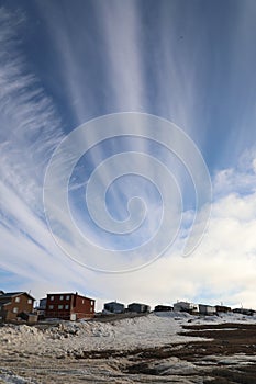 View of an high arctic community and neighbourhood with blue skies and some snow on the ground