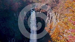 View of high Kegon Waterfall at the cliff of mountain with the colorful autumn foliage