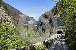 View of high mountains with a tunnel entrance and an arch bridge