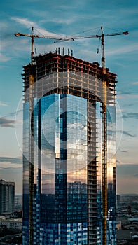 view High rise building under construction with glass facade panels photo