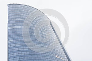 View of high rise glass office building on blue sky background,