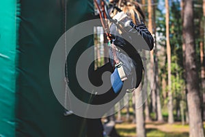 View of high ropes course, process of climbing in amusement acitivity rope park, passing obstacles and zip line on heights in