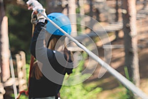 View of high ropes course, process of climbing in amusement acitivity rope park, passing obstacles and zip line on heights in