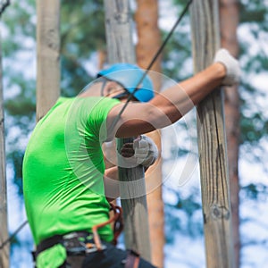 View of high ropes course, process of climbing in amusement acitivity rope park, passing obstacles and zip line on heights in