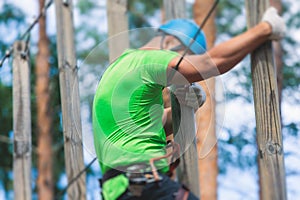 View of high ropes course, process of climbing in amusement acitivity rope park, passing obstacles and zip line on heights in