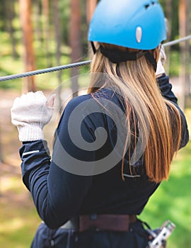 View of high ropes course, process of climbing in amusement acitivity rope park, passing obstacles and zip line on heights in