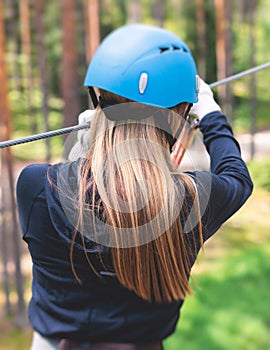 View of high ropes course, process of climbing in amusement acitivity rope park, passing obstacles and zip line on heights in