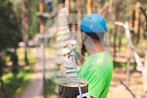 View of high ropes course, process of climbing in amusement acitivity rope park, passing obstacles and zip line on heights in