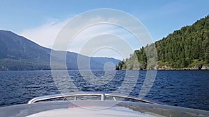 View from a high-speed motor boat with a fast forward movement on lake Teletskoye in the Altai Republic in Russia.