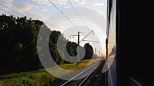 The view from the high-speed train on the beautiful scenery with hills and forest before sunset. The view from the