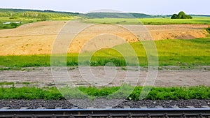 The view from the high-speed train on the beautiful scenery with hills and forest. The view from the window of the car