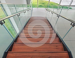 A view from high to the bottom of a modern luxury staircase in a office building glass transparent side hand guard handrail