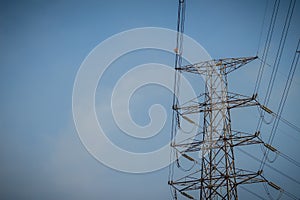 View of high voltage post on blue sky background.Electric transmission tower with cable in sky background.