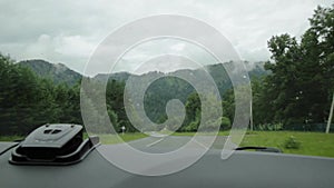 View of the highlands through the windshield during the car drive on a overcast spring morning. Picturesque country