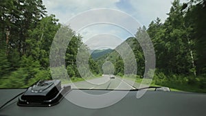 View of the highlands through the windshield during the car drive on a overcast spring morning. Picturesque country