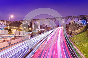 View of highway with car traffic and light trails. The Aguas Livres Aqueduct Aqueduto das ÃÂguas Livres in Lisbon, Portugal photo