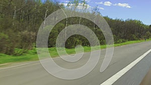 View of the highway road in the countryside, field, forest and sky on a sunny day