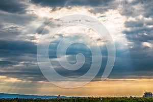 View from the highway to Kovilj city and the mountain Fruska Gora from Serbia. Black clouds over the urban city with sun rays pene