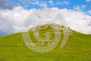 View of the hill over which the village road goes and the clouds that rise above the hill in Å½abljak in Montenegro.