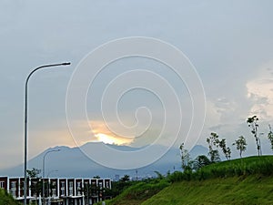 A view of the hills with mountains accompanied by a beautiful sunset