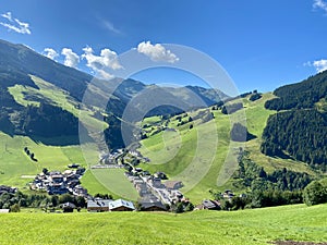 View of Hinterglemm village and mountains with skiing lifts in Saalbach-Hinterglemm skiing region in Austria on a
