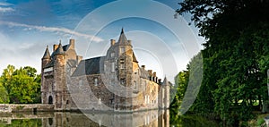 View of the historic Chateau Trecesson castle in the Broceliande Forest with reflections in the pond