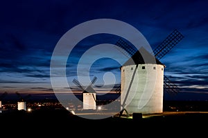 View of the historic white windmills of La Mancha above the town of Campo de Criptana at sunset