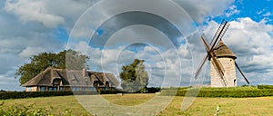 View of the historic windmill Moulin de Pierre and miller`s house in Hauville in Normandy