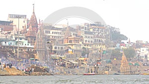 View of the holy city of Varanasi from the ghats. Boats anchored on the banks of the river