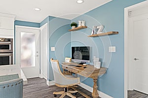 View of home office space with wooden table and blue painted wall