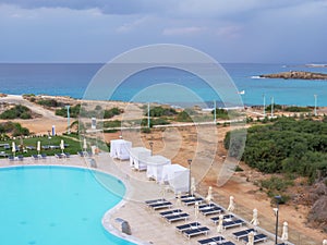 View from the hotel balcony over Nissi promenade between blue sea and empty swimming pool